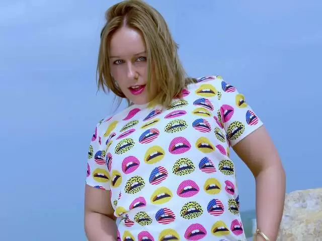 blonde doing a strip by the beach photo 1