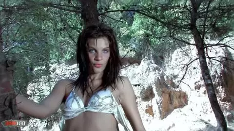 A wonderfull blue eyed babes is sttriping in the wood