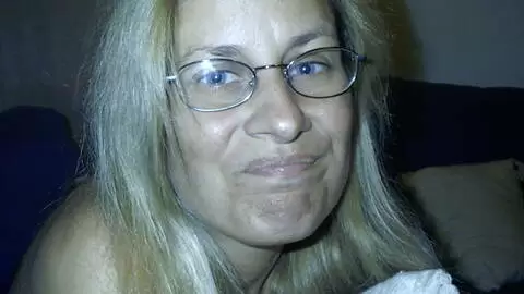 Mature blonde with big boobs Martha stripping on the bed 